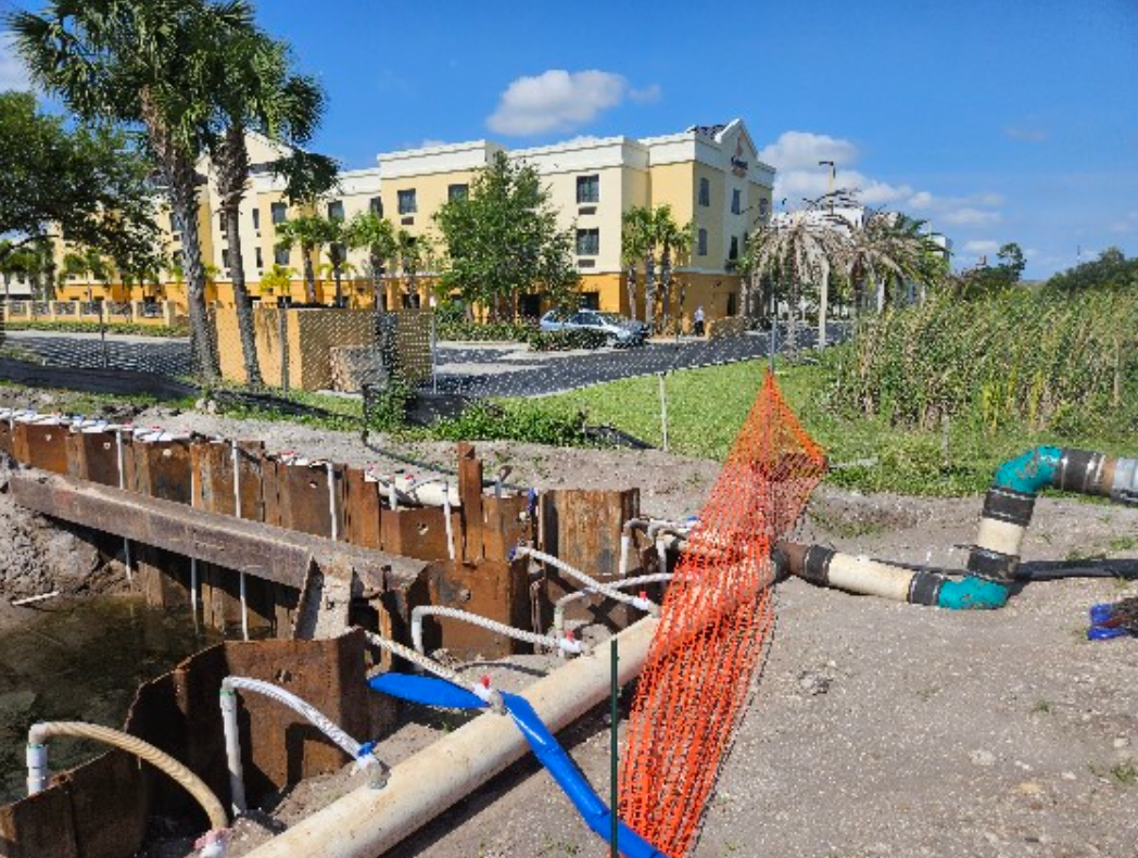 A construction site with a large building in the background.