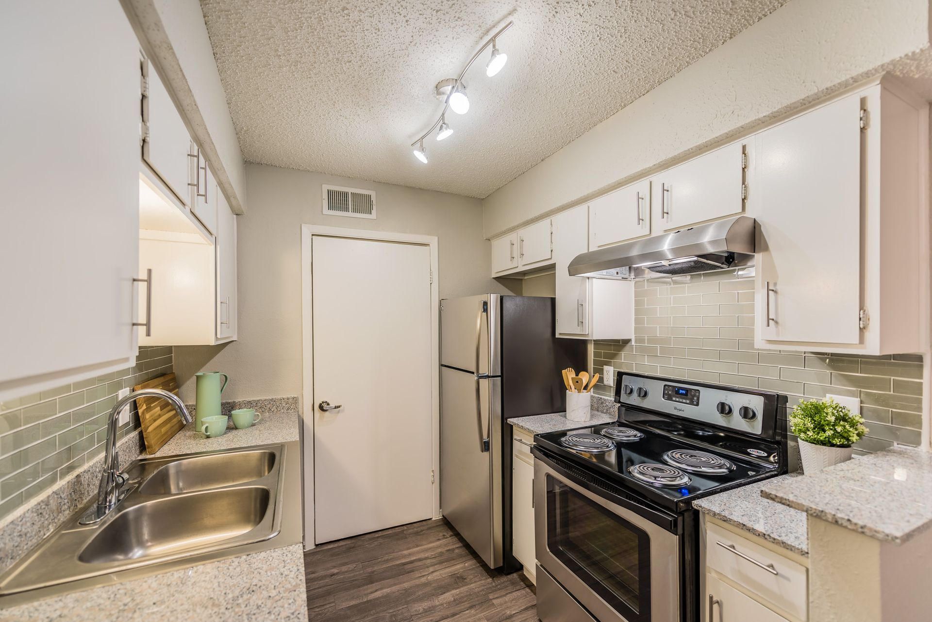 Kitchen with white cabinets, stainless steel appliances, and gray countertops.