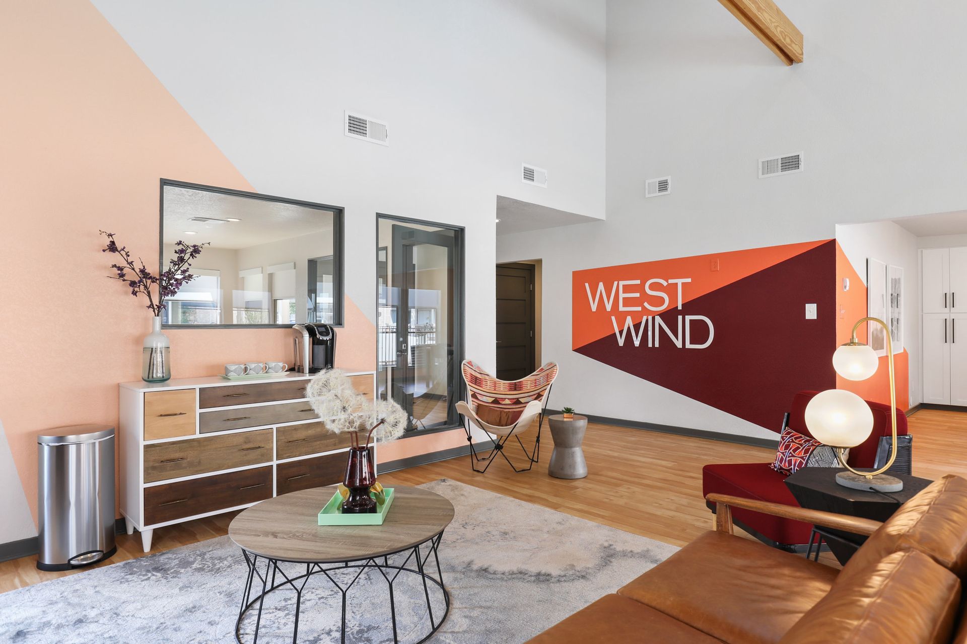 Interior of a brightly lit lobby with a color-block wall and the words 
