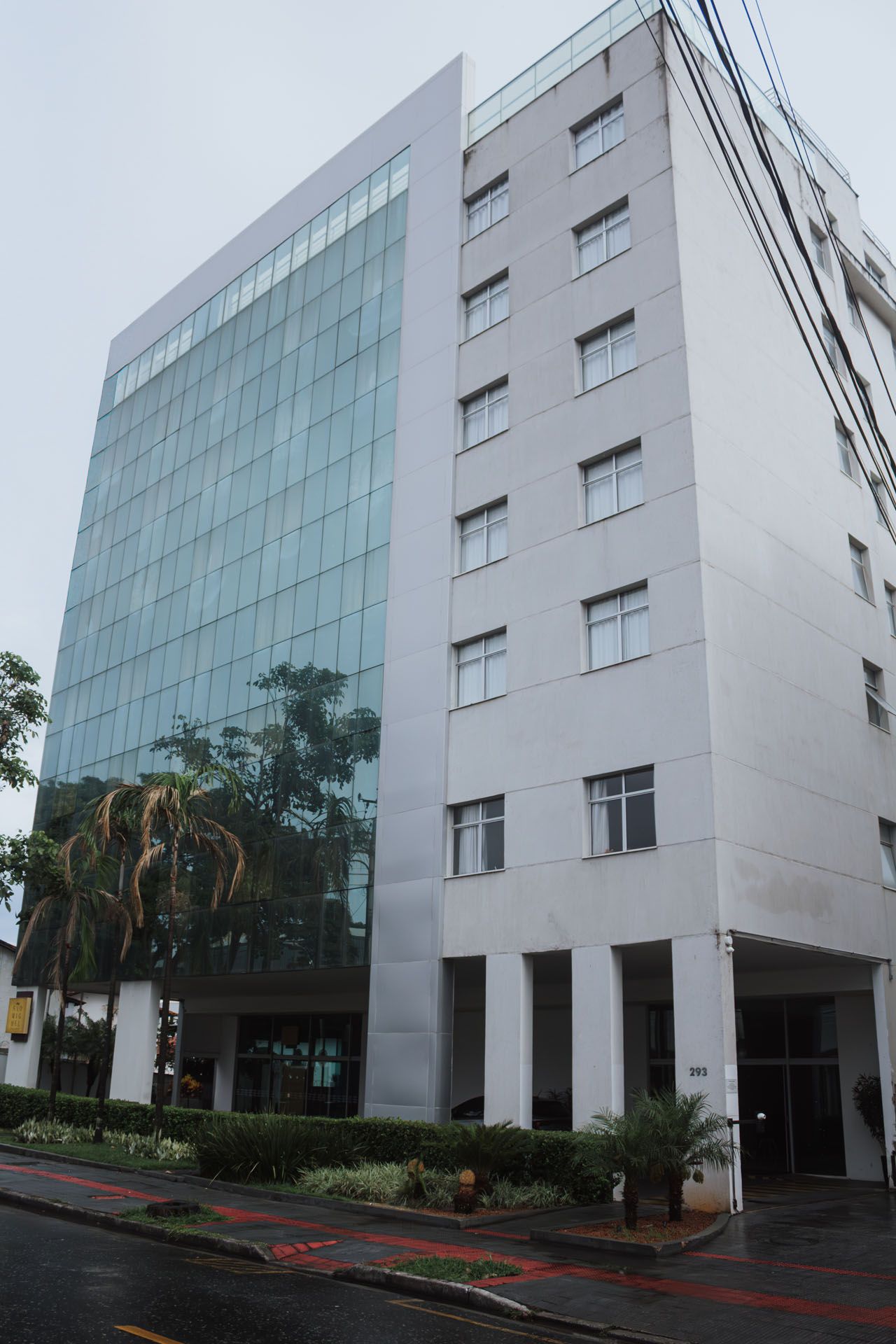 Edifício de escritórios moderno com fachada de vidro e exterior branco.