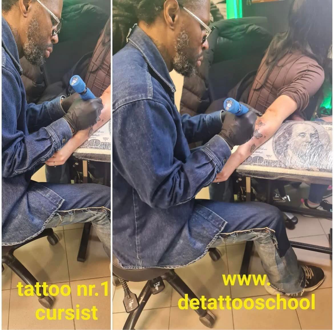 Een persoon tatoeëert een arm, draagt ​​een spijkerjack en zwarte handschoenen. De setting is binnen.