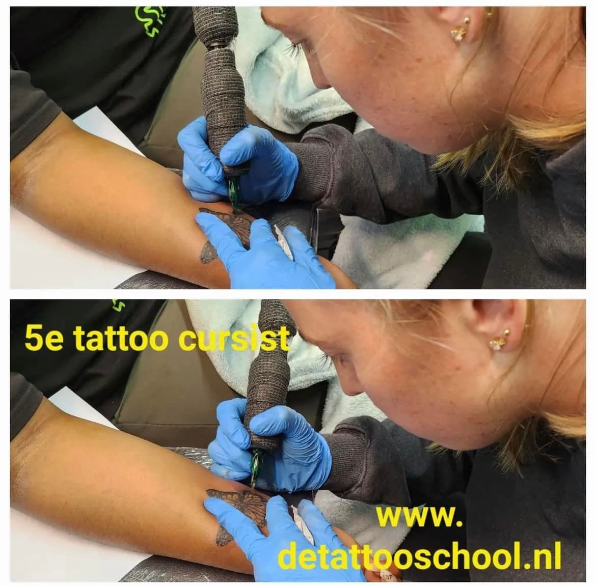 De gehandschoende handen van een tatoeëerder die een tatoeagepistool op een arm gebruikt. Een blonde vrouw buigt zich voorover en werkt. Tekst: 