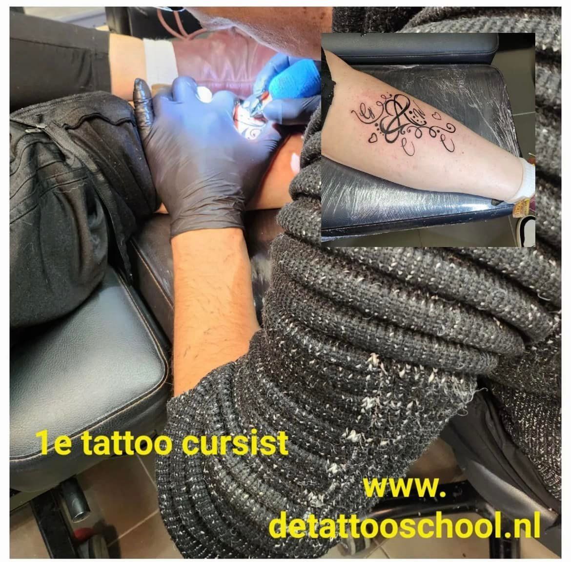 Tatoeëerder zet een tatoeage op iemands arm. Tatoeëermachine in gebruik, zwarte handschoenen, armleuningen.