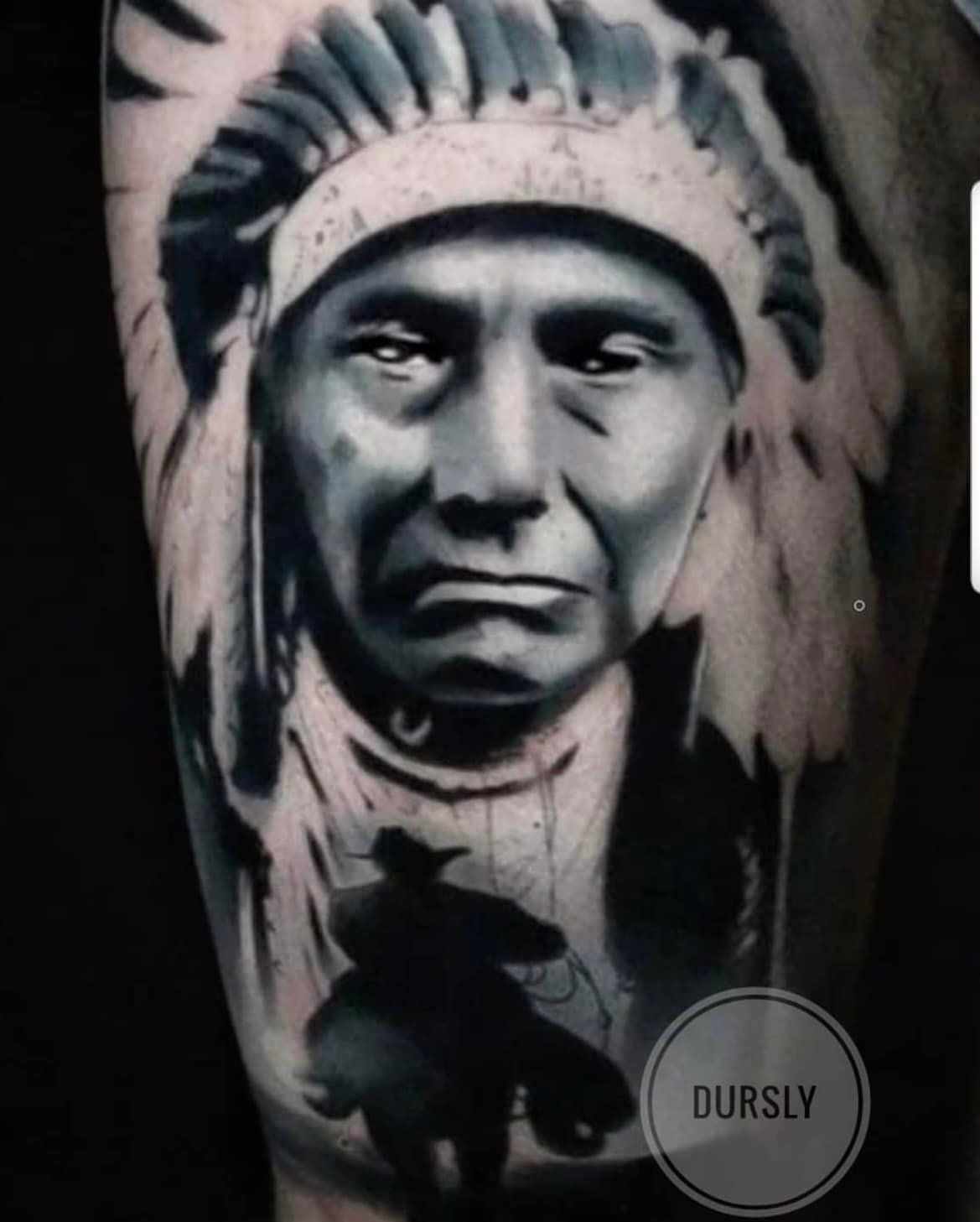 Zwart-witte tatoeage van een Indiaanse leider met een veren hoofdtooi, met daaronder het silhouet van een ruiter.