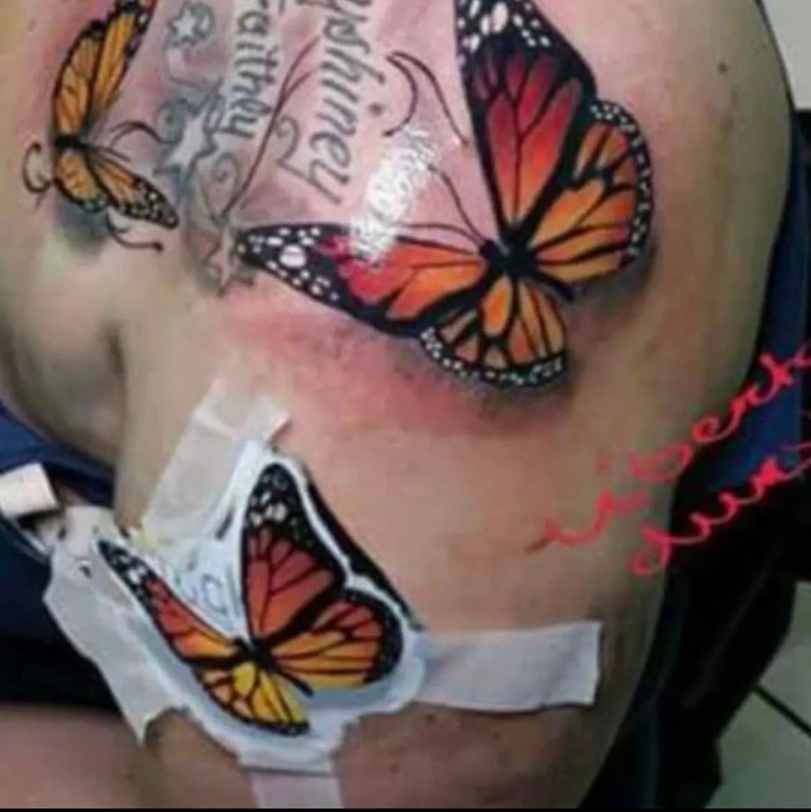Tatoeage van oranje en zwarte vlinders op de huid van een persoon, met in de buurt een beveiligde medische poort.