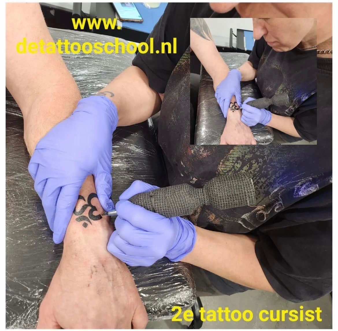 Persoon die een pols tatoeëert; close-up met inzet. Handen dragen blauwe handschoenen. Zwarte tatoeage op arm.