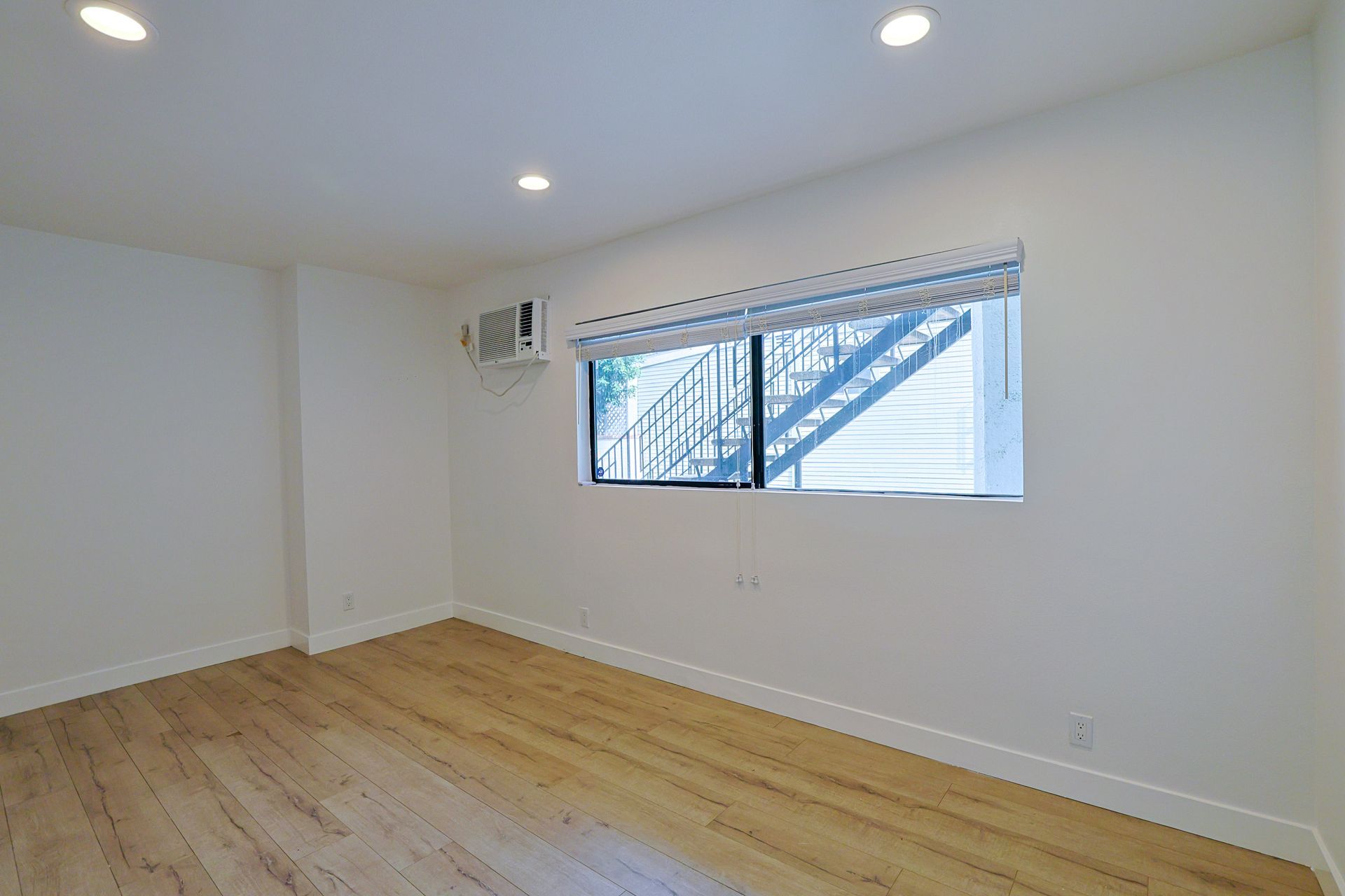 THis image showing a blank room with two windows in it.