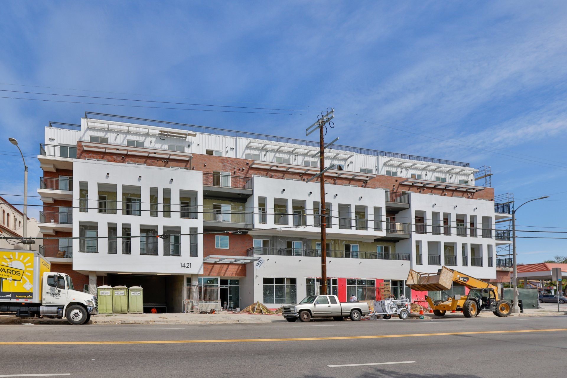 This image showing a building infront of the  road wuith lots of vehicles in ir.