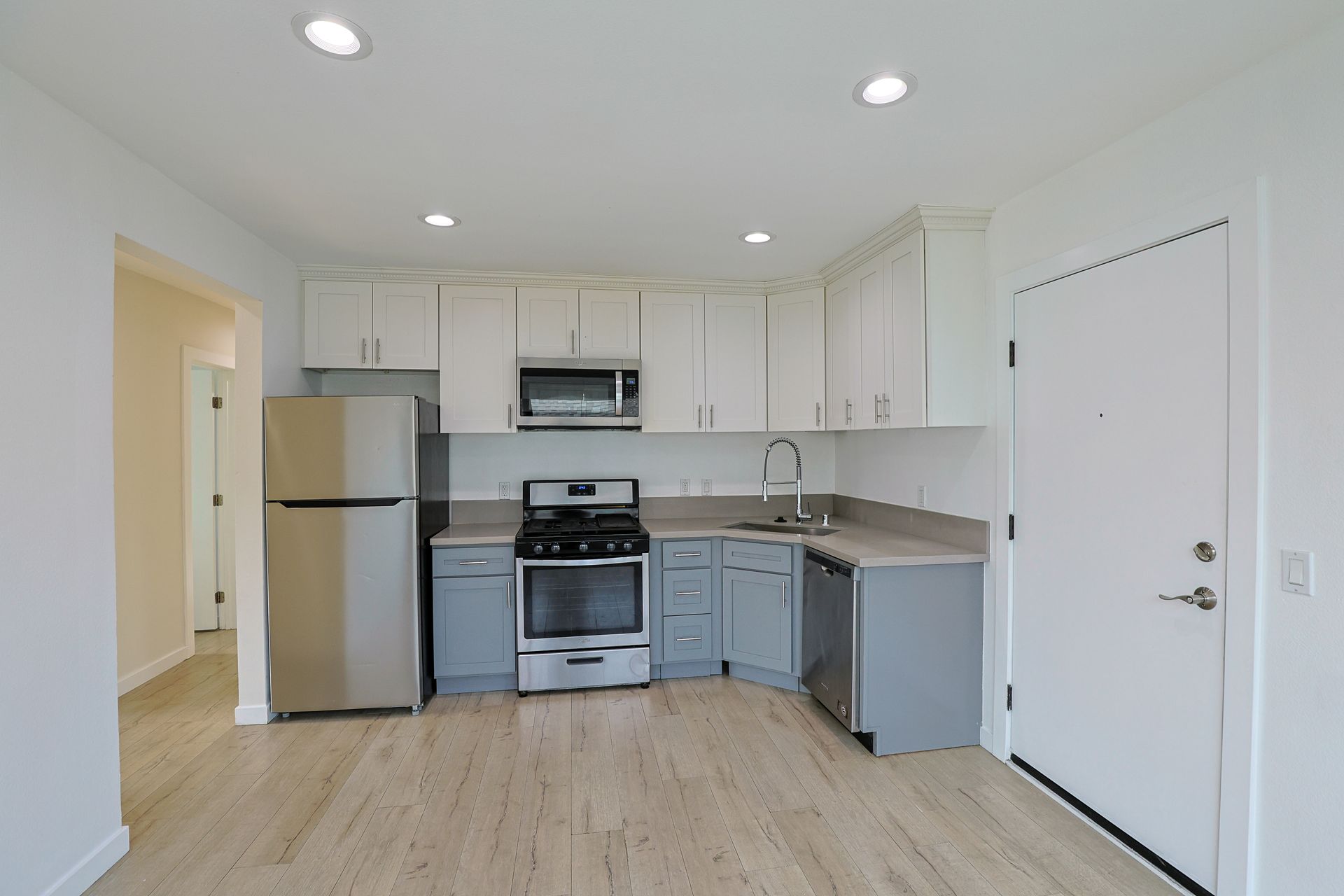This image showing a kitchen in a spacious room with lot of aaccessories in it.