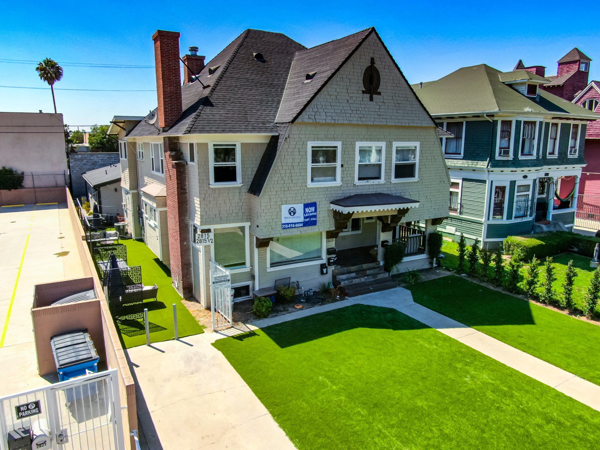 This image shows two houses  with a lawn and a sidewalk in the society.