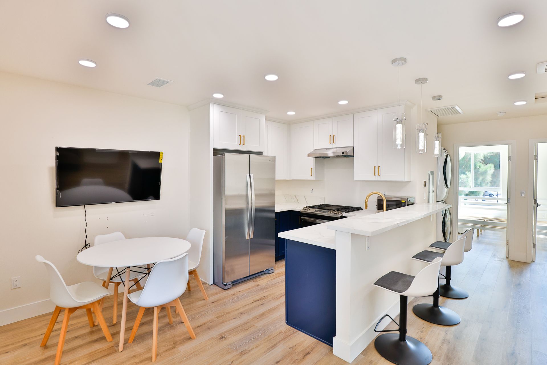 This image shows a white theme kitchen with a table and chairs.