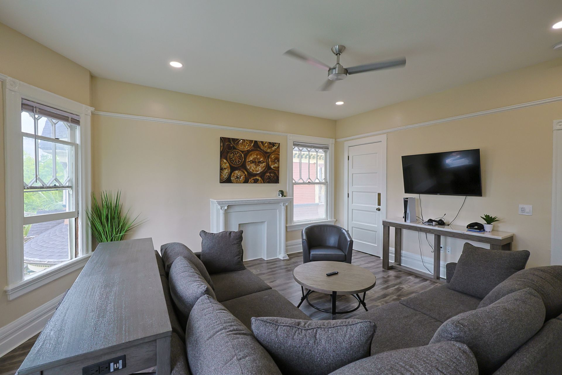 This image showing a living room with with furniture and smart tv in it.
