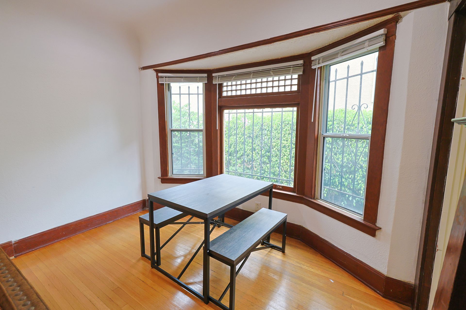 This image showing a two seater table with window in a spacious room.