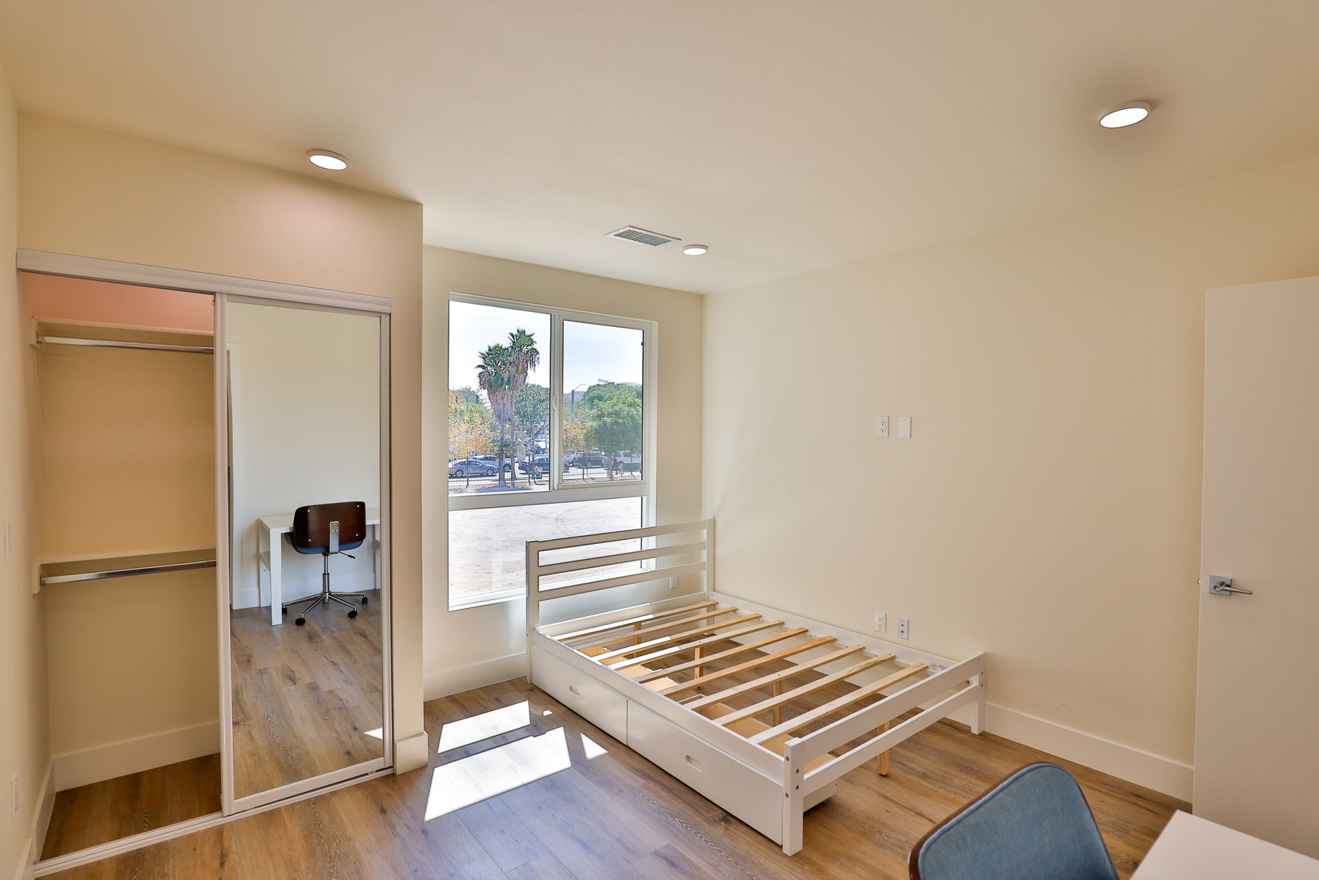 This image shows a bown theme room with a bed and a mirror.