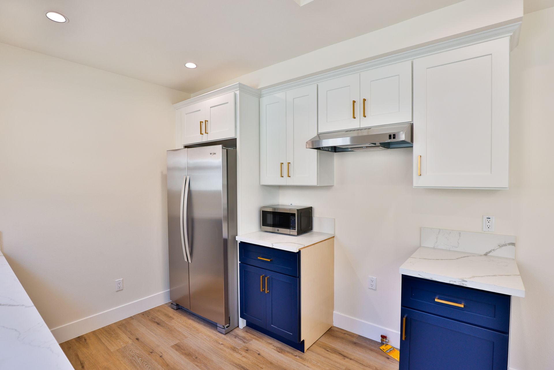 This image shows a kitchen with white cabinets and blue cabinets.