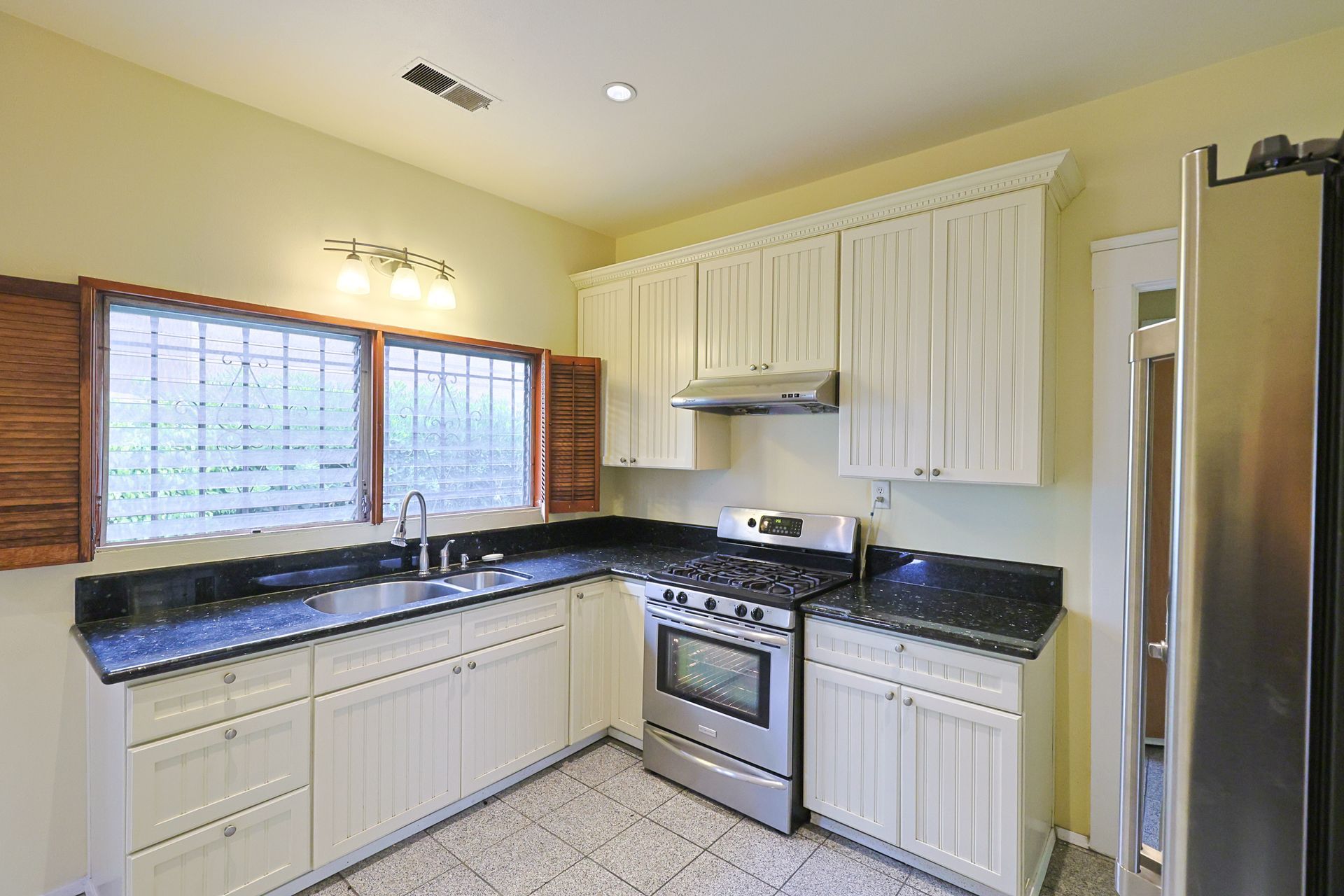 this image shows a kitchen of a house with yellow background