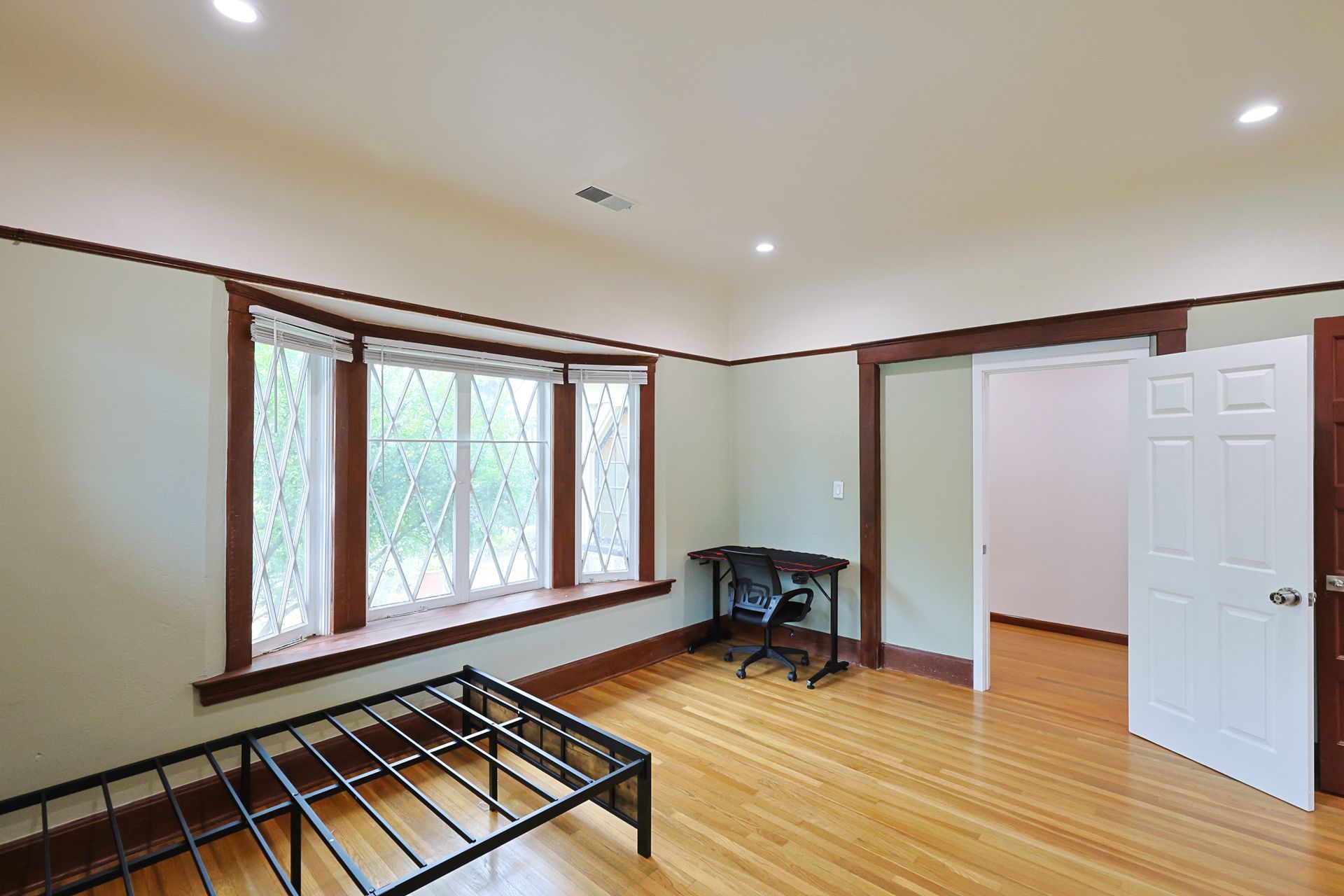 This image showing a spaciolus room with one door, furniture and windows in it.