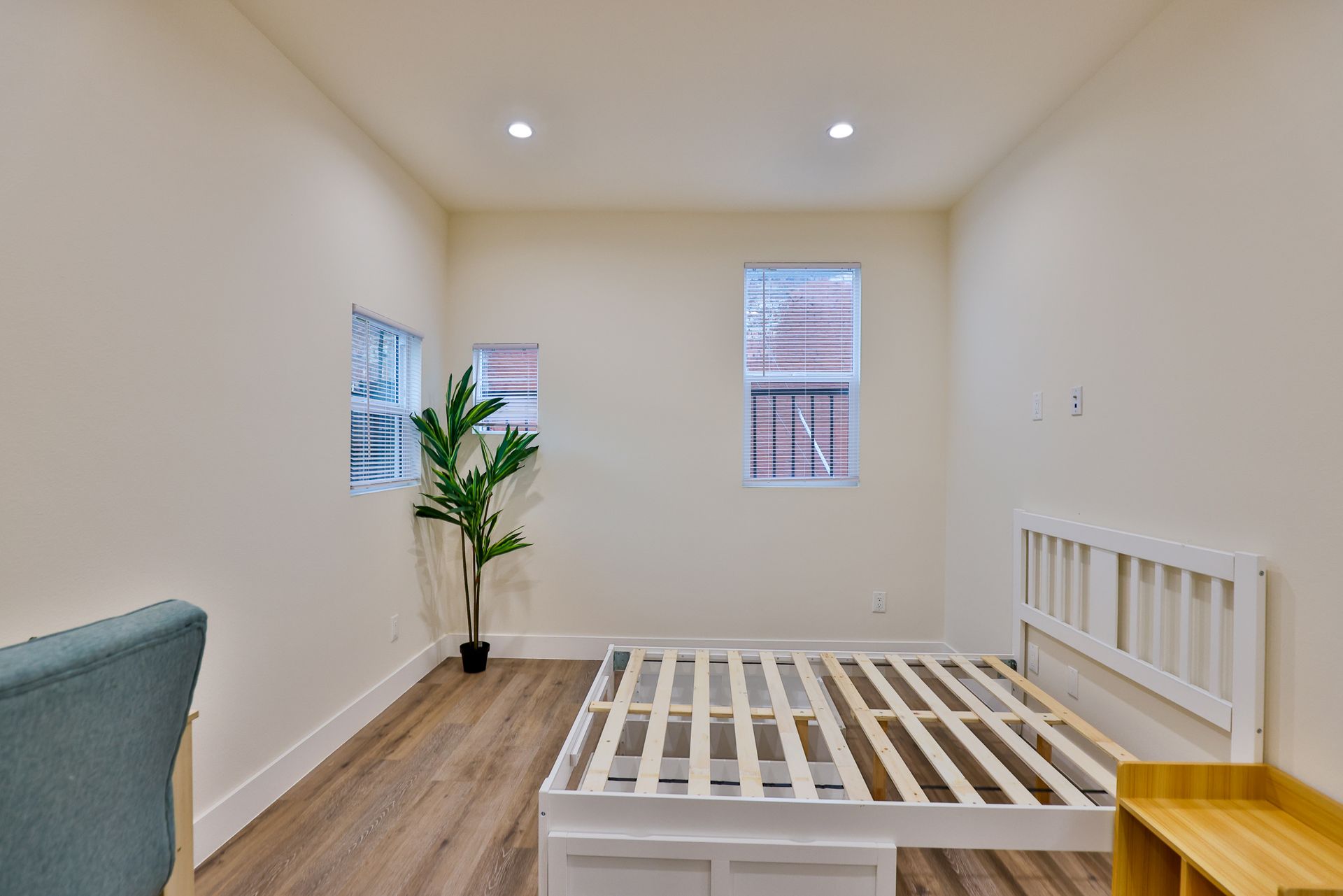 This image showing a beautiful room with three windows and furniture in it.