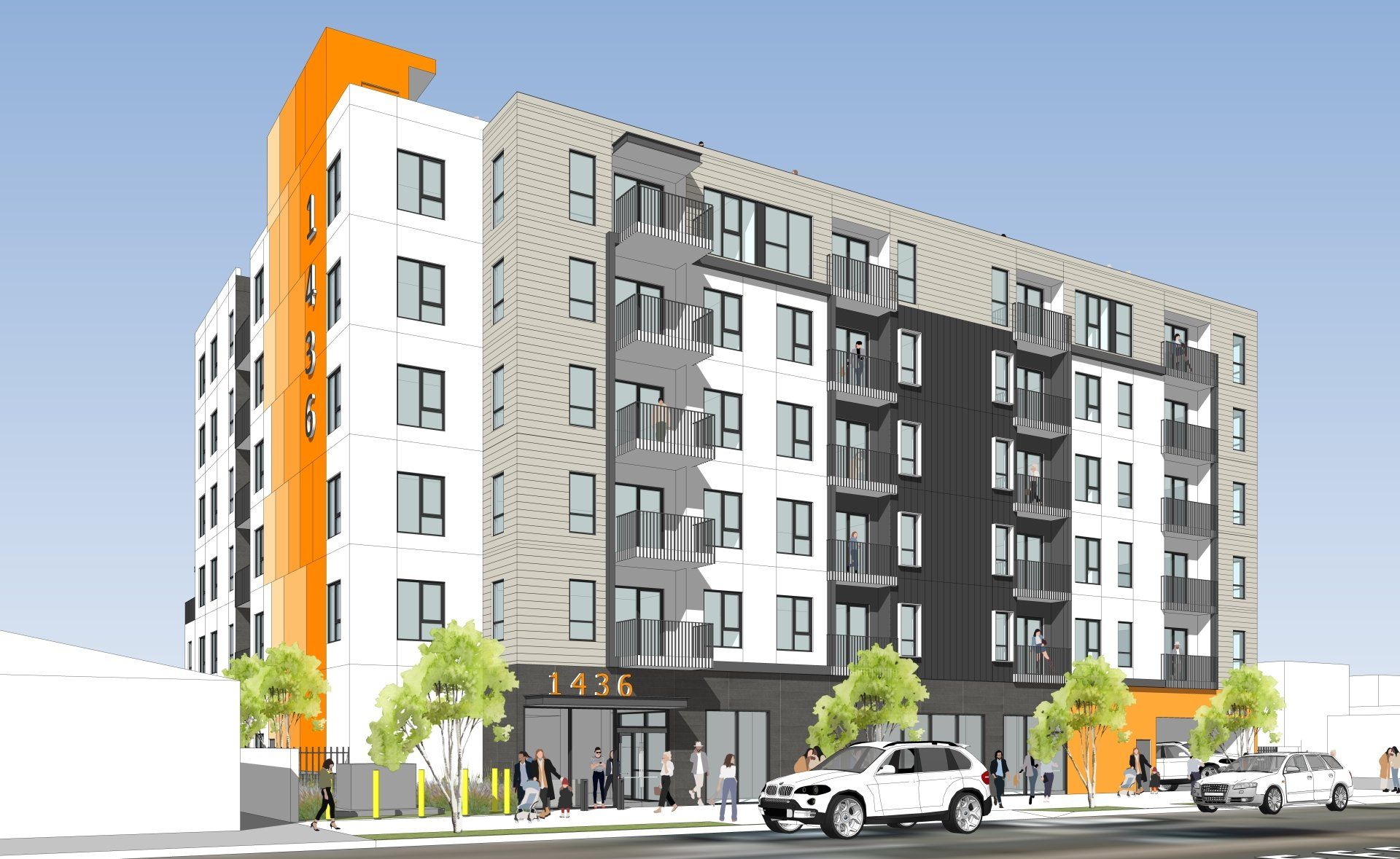 This image showing a colorful building, trees, cars,and roads in front of it.