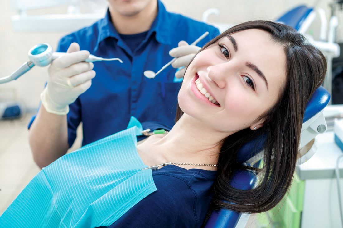 paziente sorridente sulla poltrona del dentista
