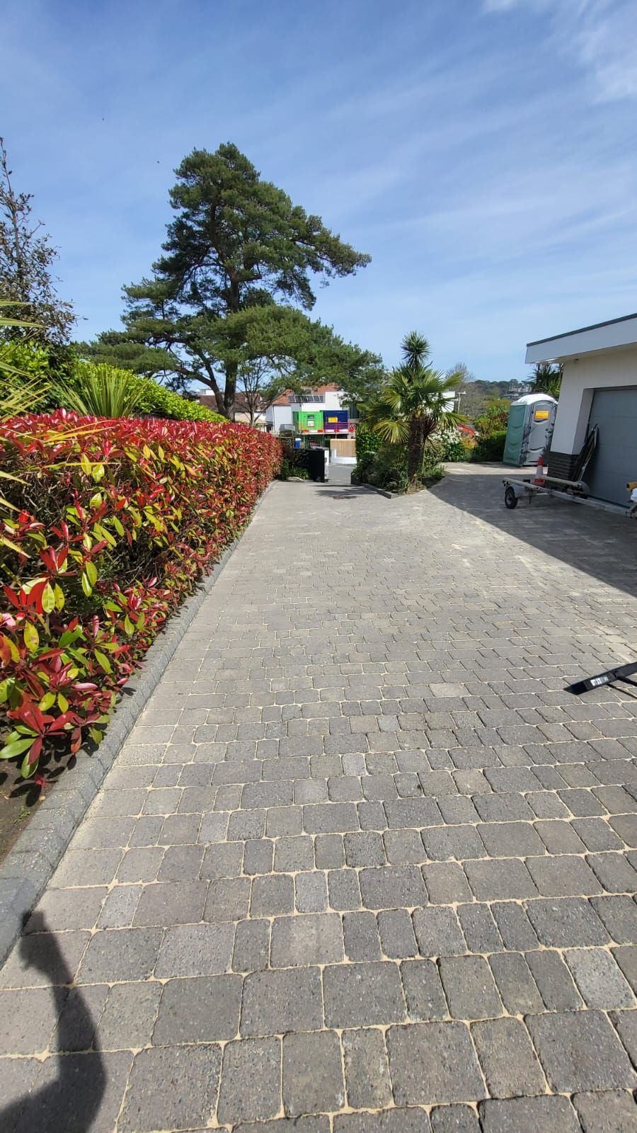 A person is walking down a brick walkway next to a house.