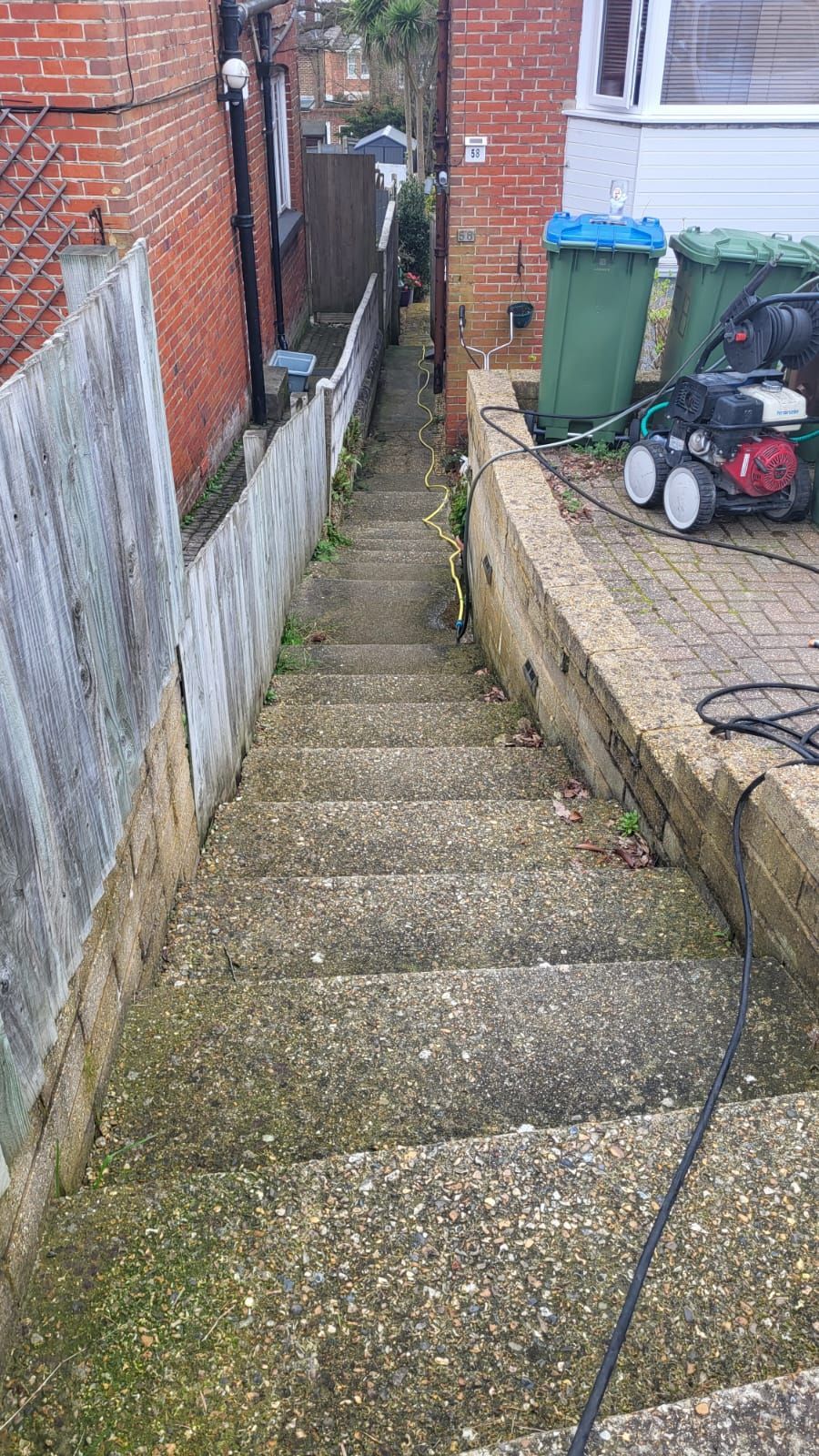 A set of dirty concrete stairs leading up to a house.