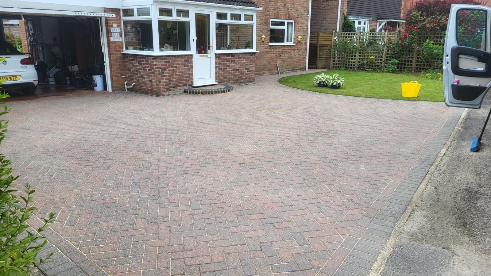 A car is parked in a driveway next to a house.