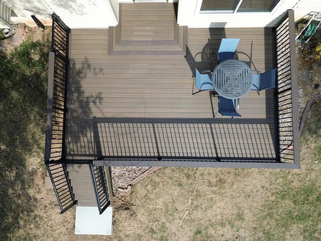 Overhead view of a composite deck with black railing and patio furniture.
