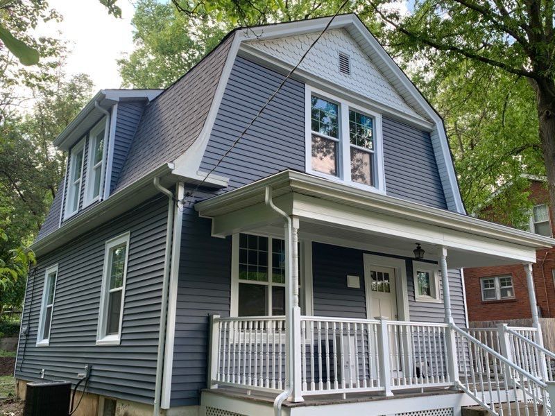 Two-story house with blue siding, white trim, and a porch.