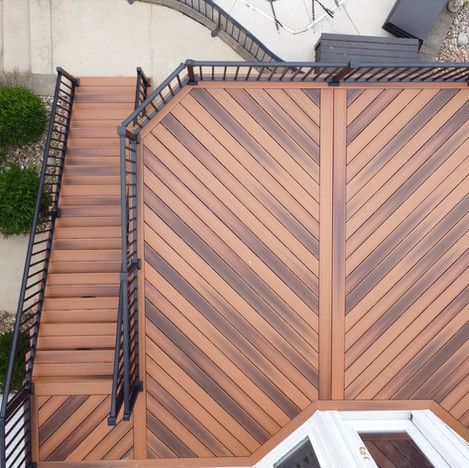 Wooden deck with dark metal railings and stairs leading down to the yard.