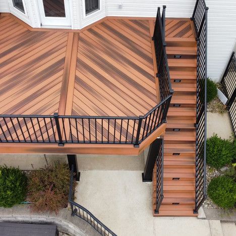 Wooden deck with stairs, black railing, and brown decking.