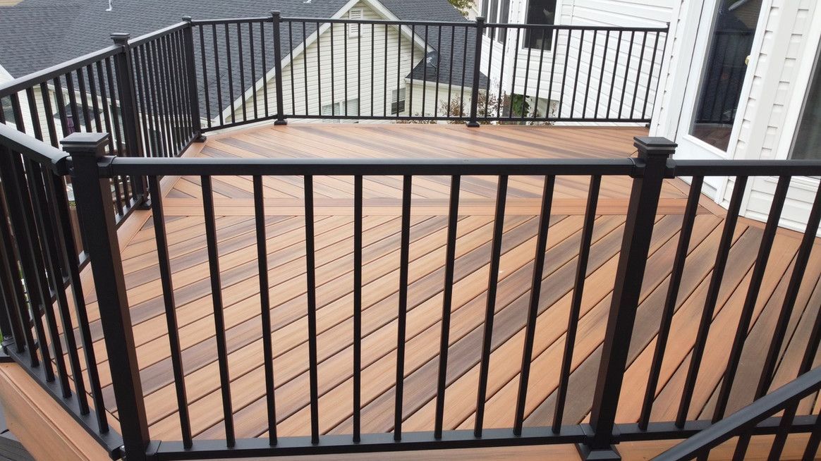 Brown wooden deck with black railings and posts.