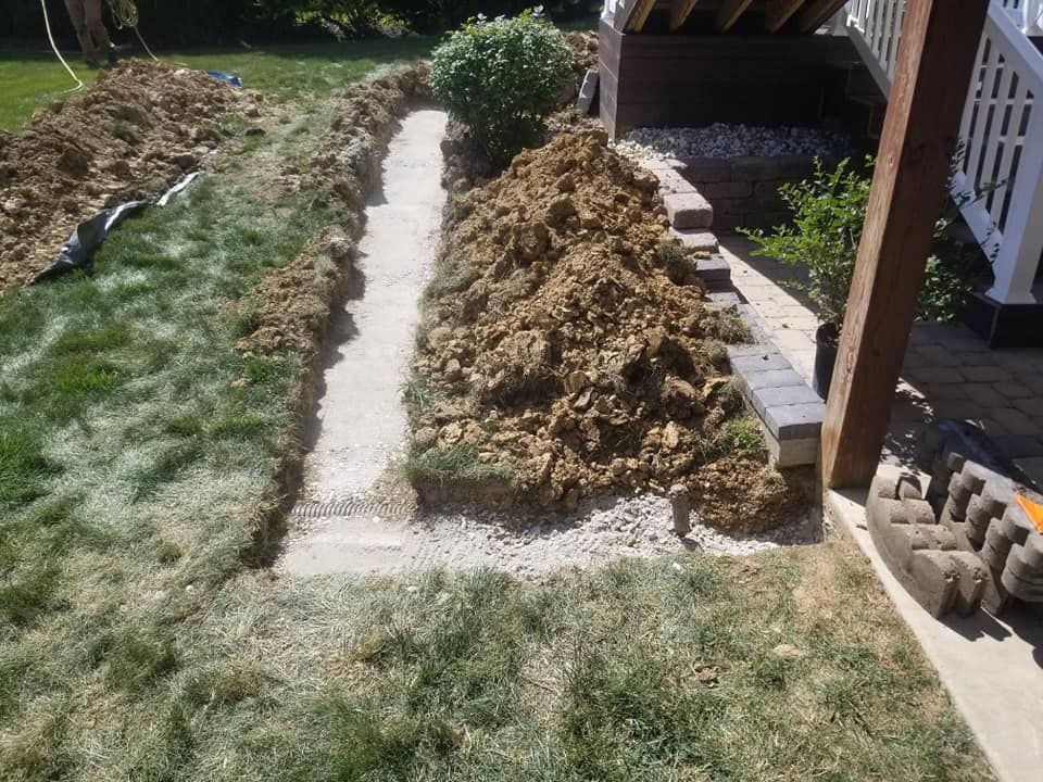 A pile of dirt is sitting in the middle of a lush green yard.