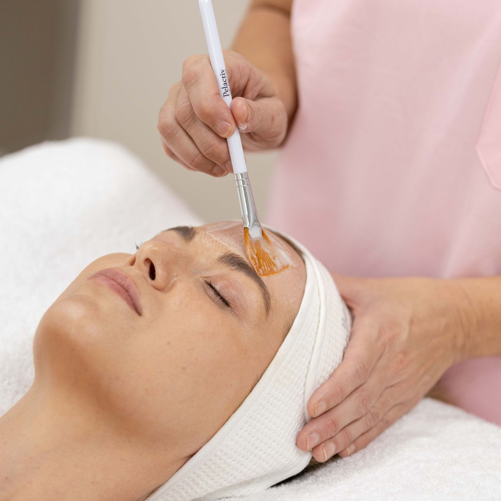 A woman is laying on a bed with a mask on her eyes.