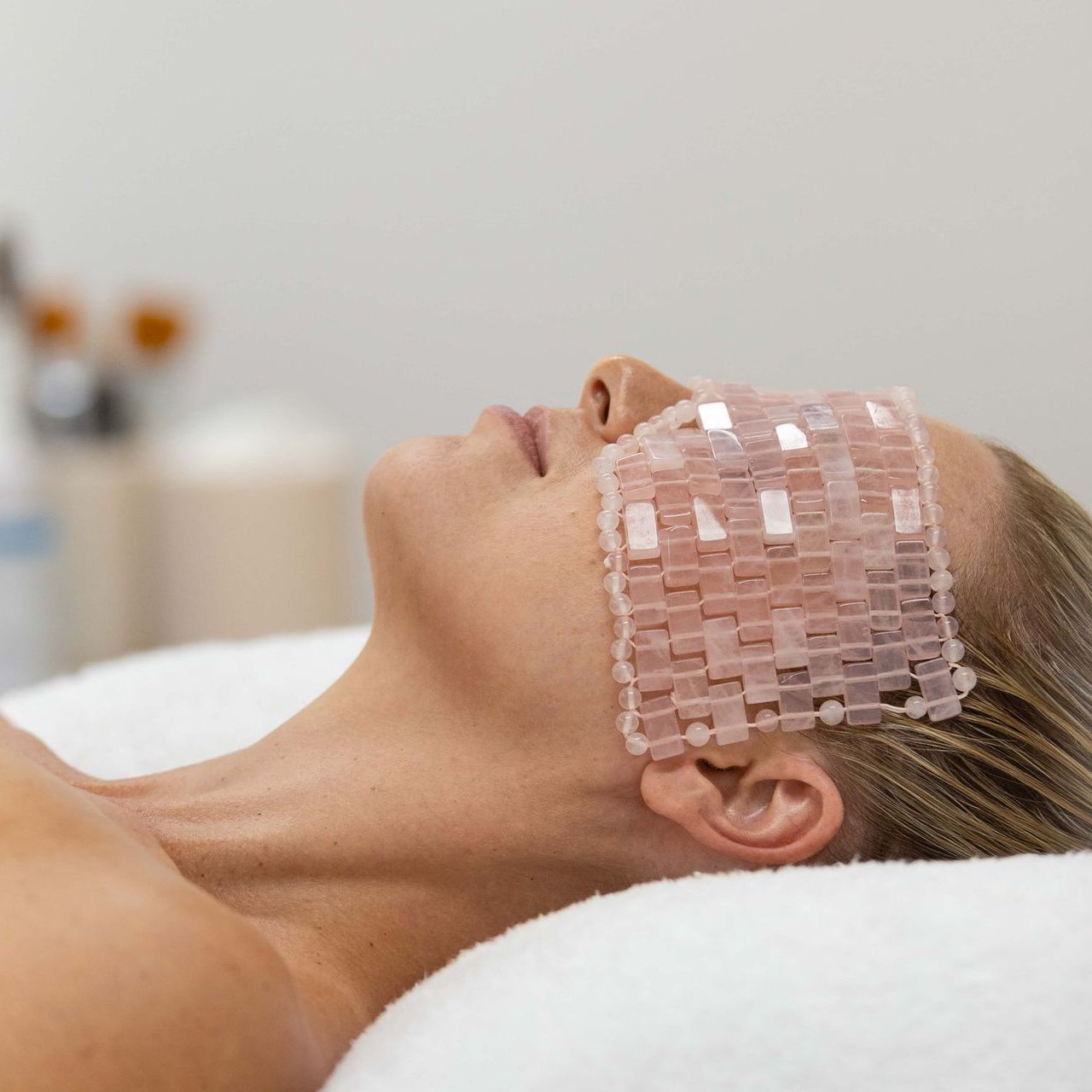 A woman is putting a mask on a woman 's face.