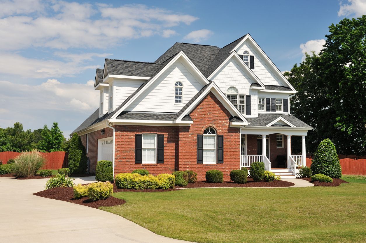 A large brick house with white trim and black shutters