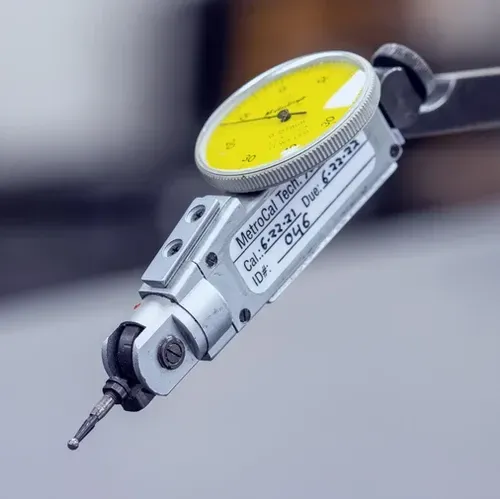 A close up of a dial gauge on a table.