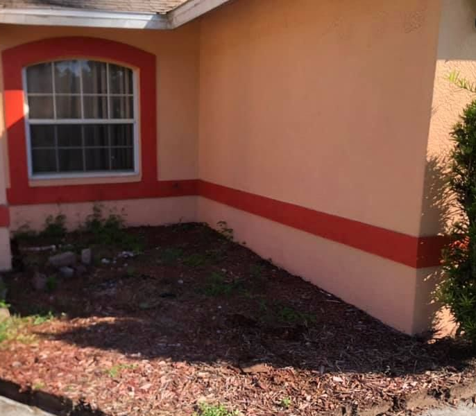 A wooden fence surrounds a swimming pool in a backyard