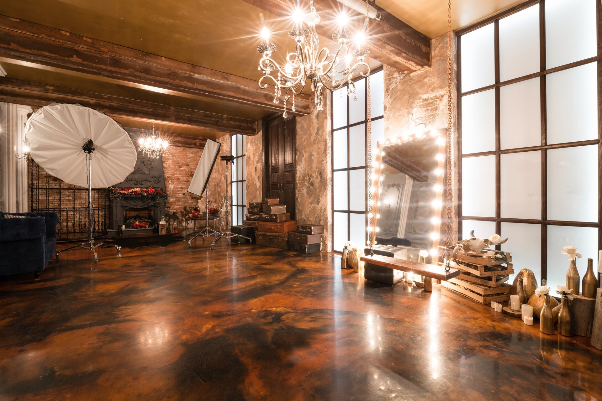 Studio loft interior featuring a mirror, candles, exposed brick wall, and a large window with concrete staining.