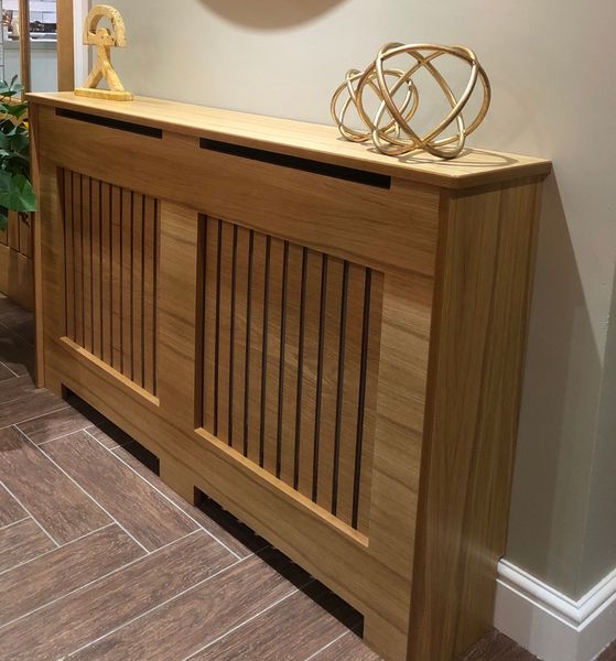 A wooden radiator cover with a sculpture on top of it