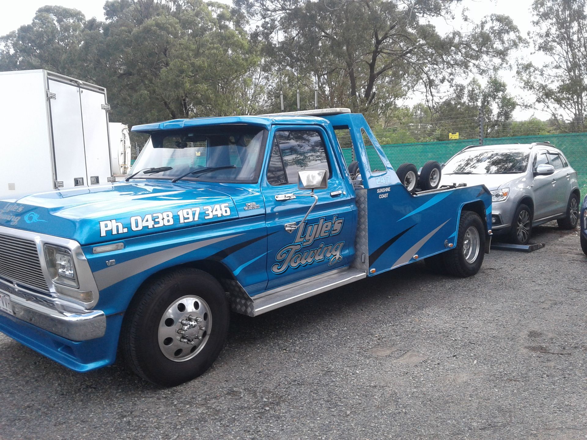 A Blue Tow Truck is Parked Next to a Silver Car — Lyle's Towing In Little Mountain, QLD