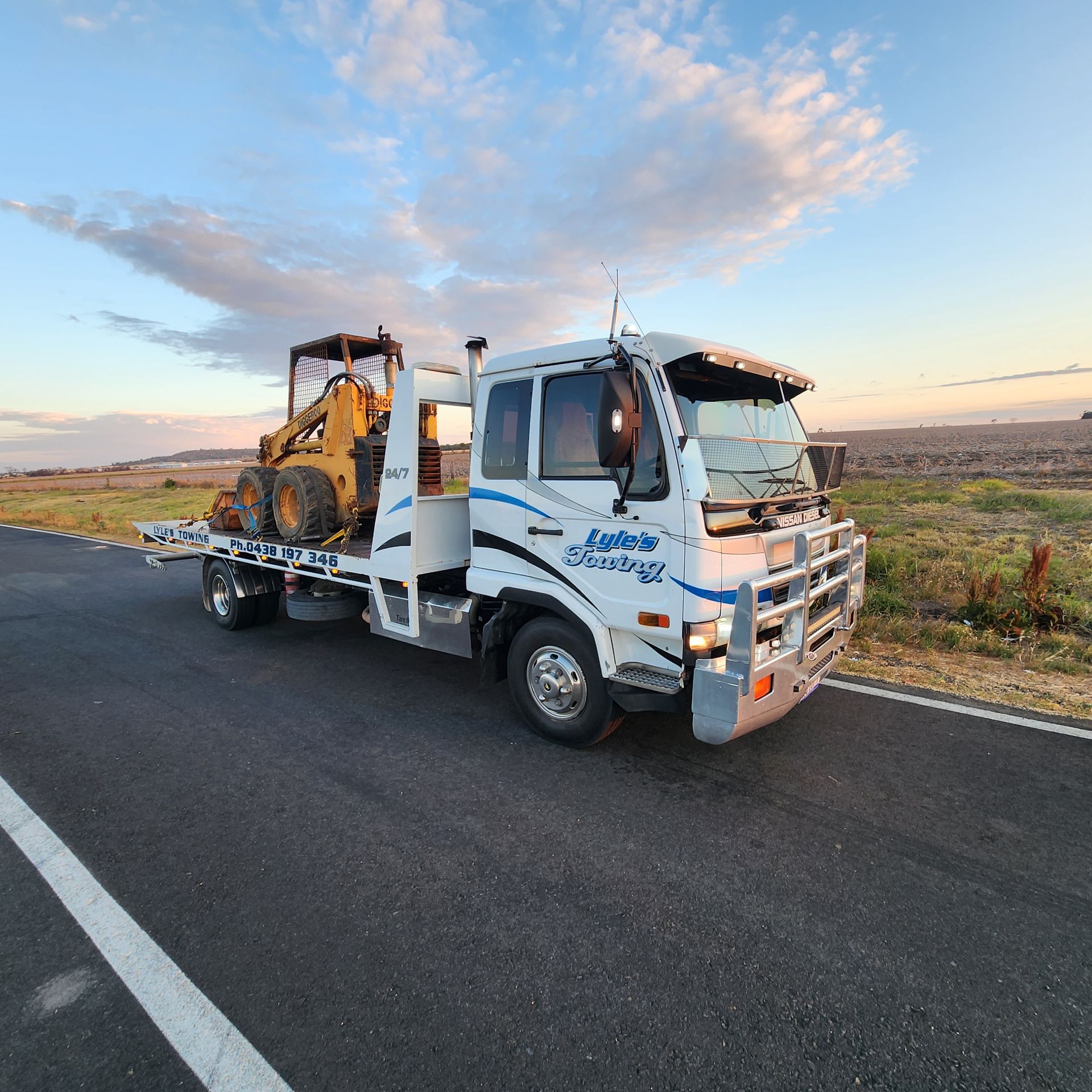 A Tow Truck towing Heavy Machinery — Lyle's Towing In Little Mountain, QLD