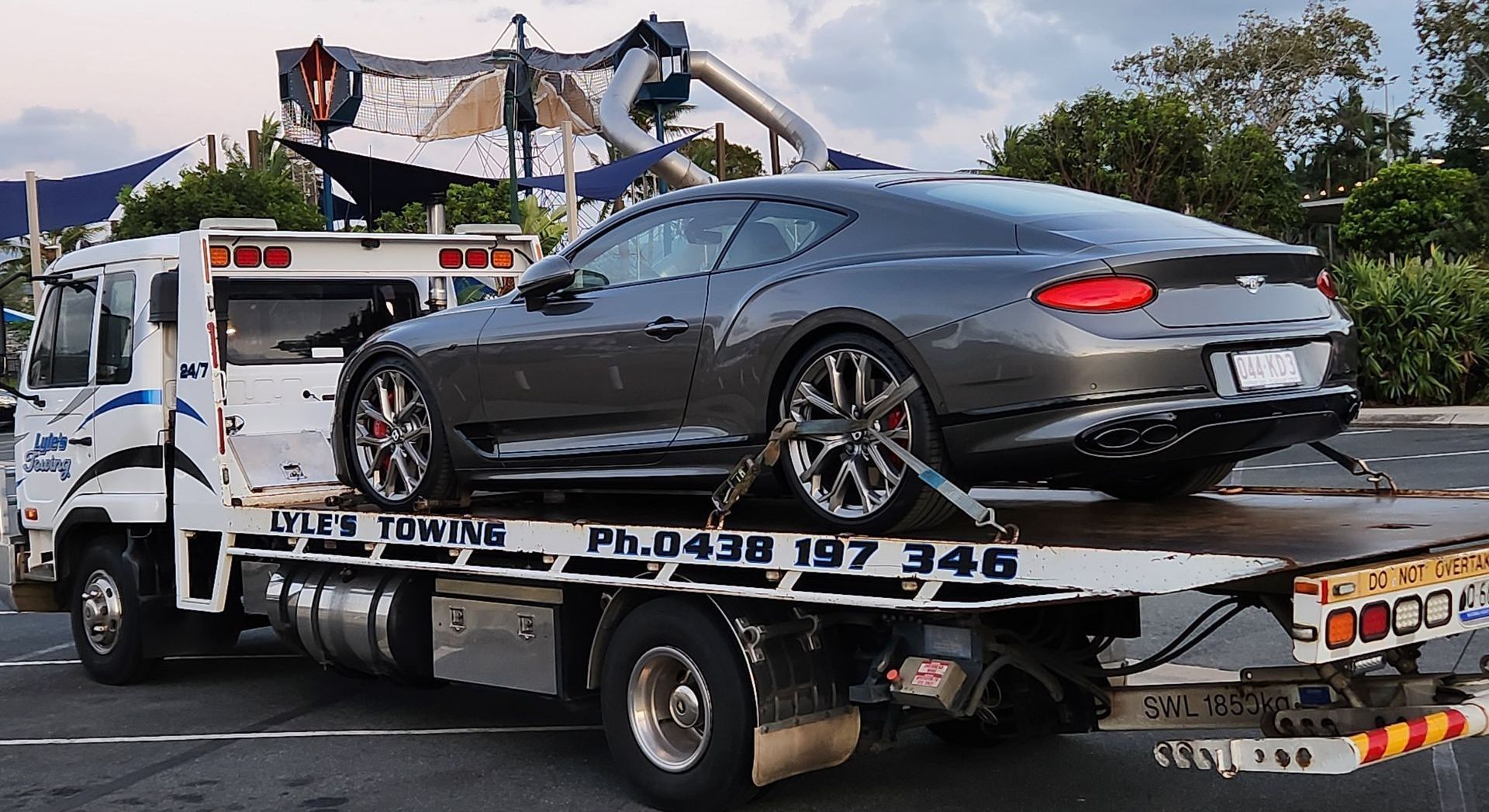 A Tow Truck towing a Black Bentley — Lyle's Towing In Little Mountain, QLD