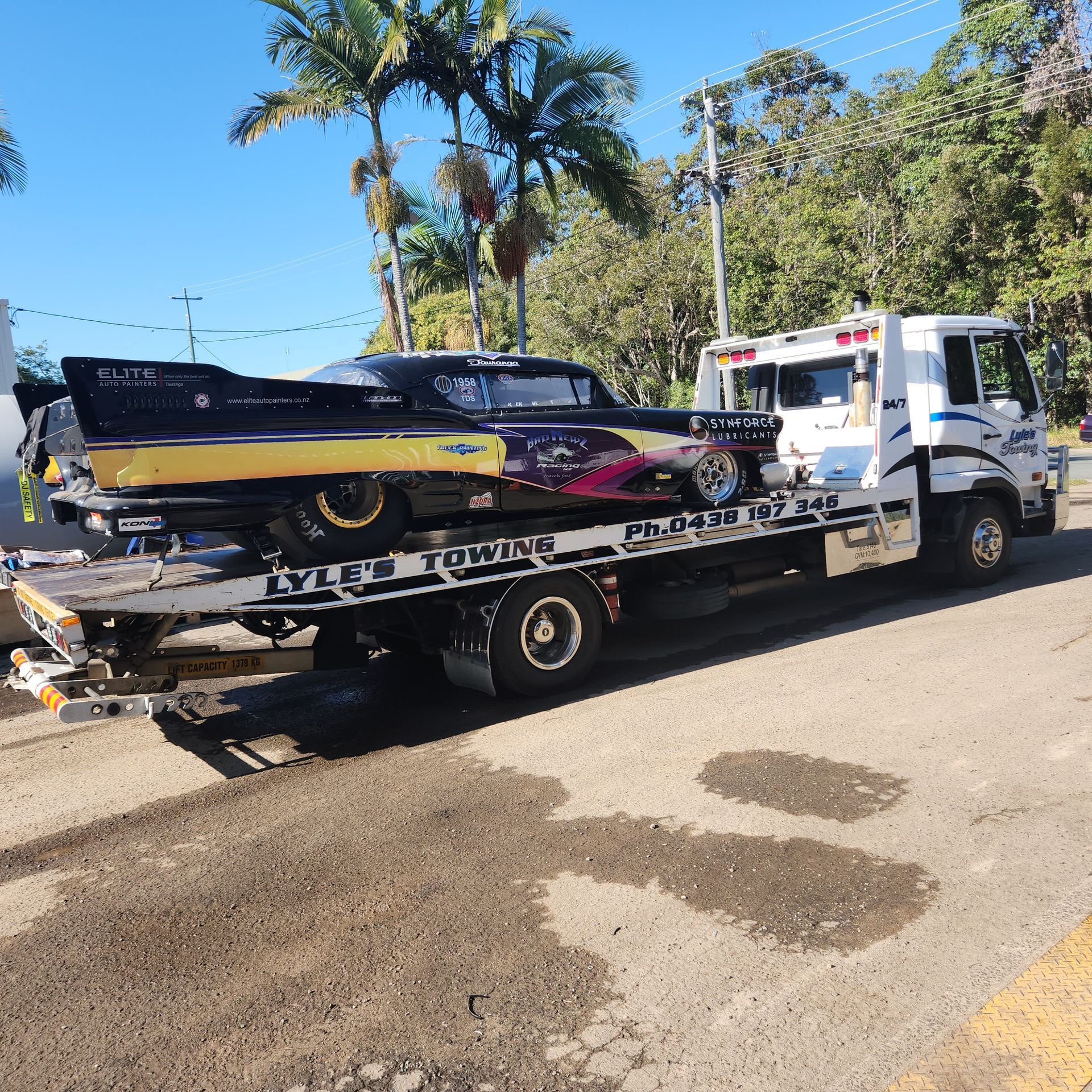 A Tow Truck towing a Drag Car— Lyle's Towing In Little Mountain, QLD
