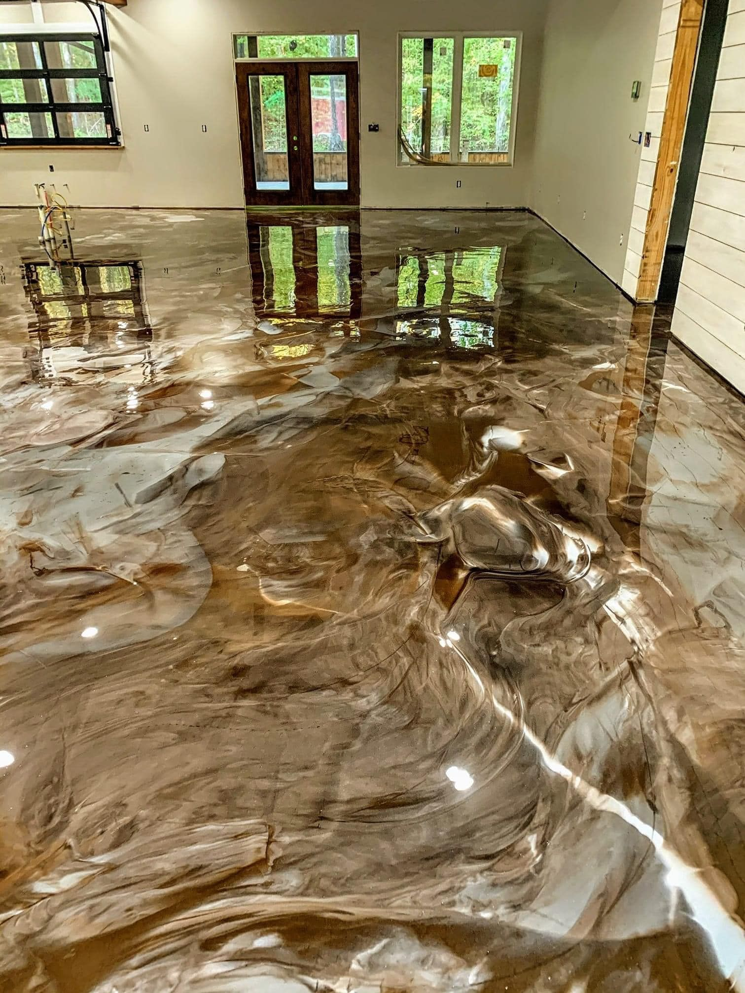 Metallic epoxy floor in shades of brown with reflective, swirling patterns.
