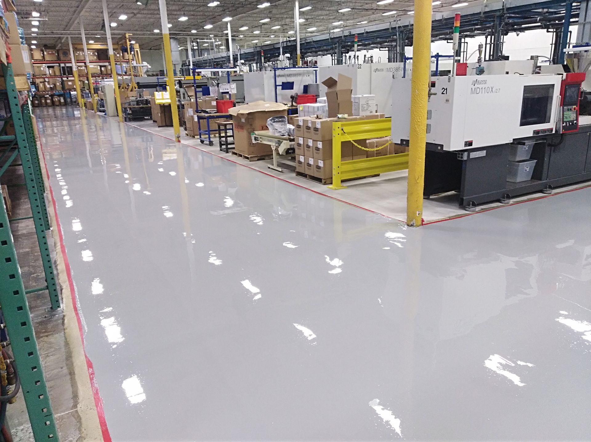 Factory interior with light gray epoxy floor and industrial machinery.
