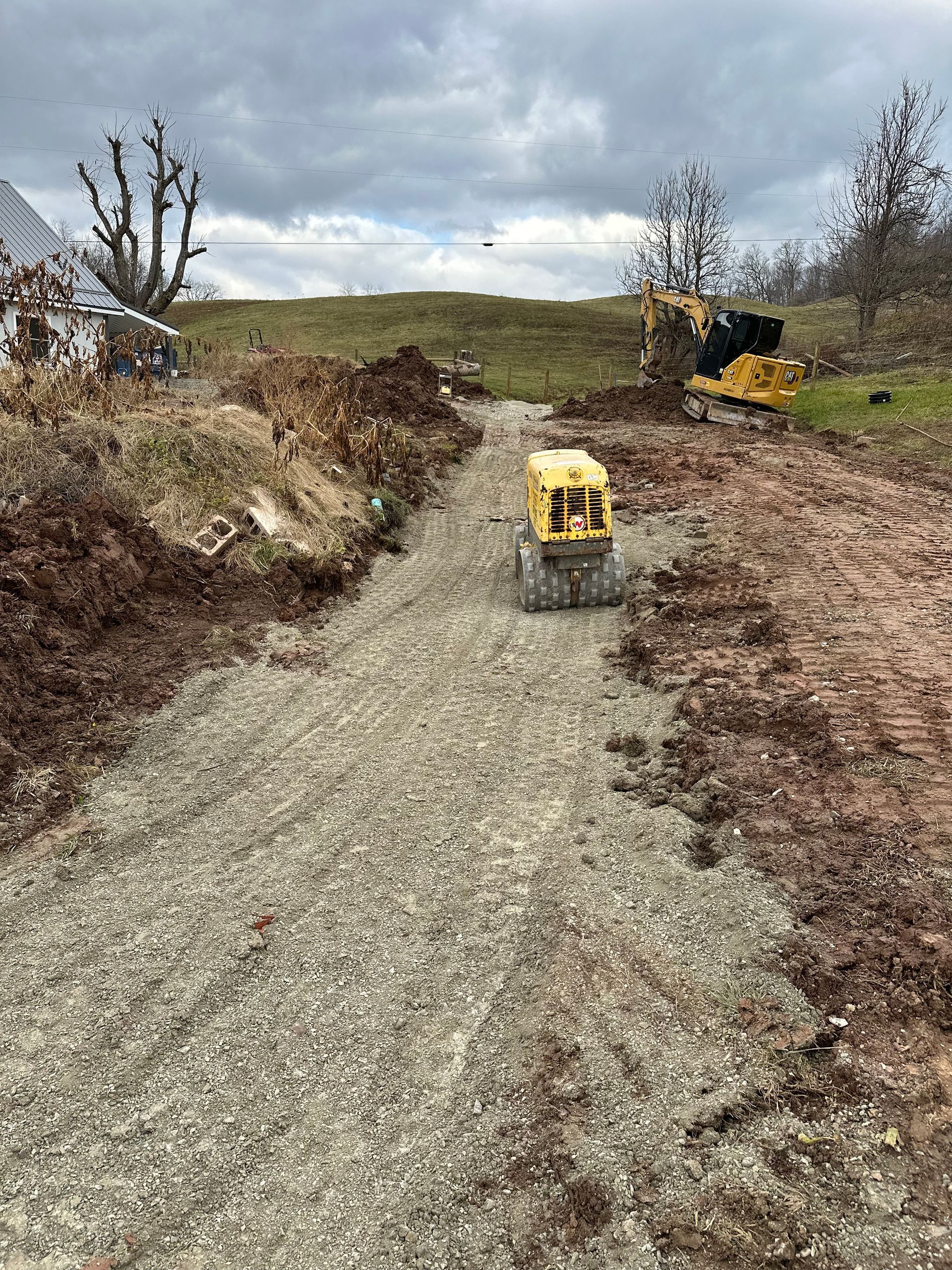 A yellow truck is driving down a dirt road.