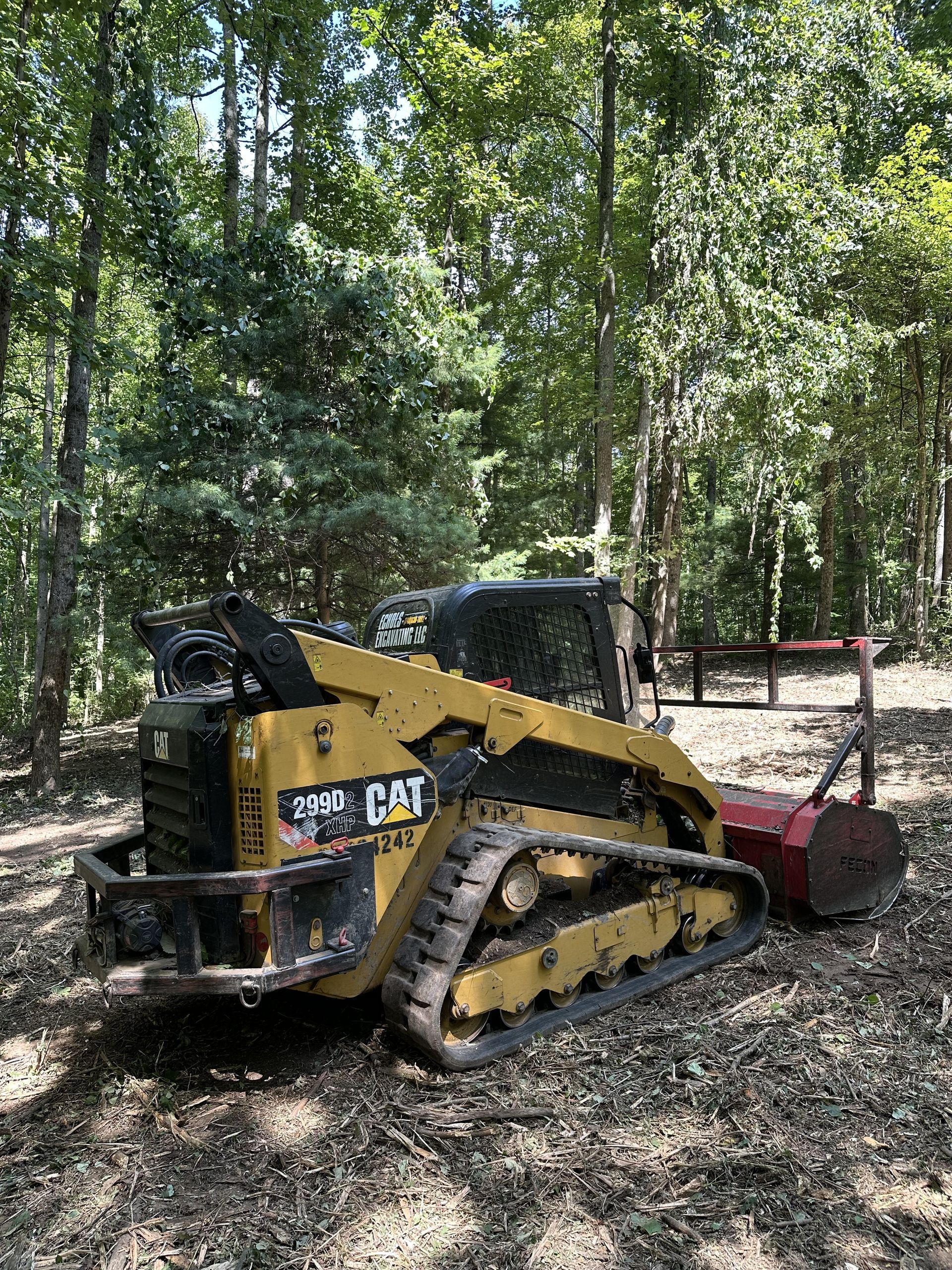 A bulldozer is parked in the middle of a forest.