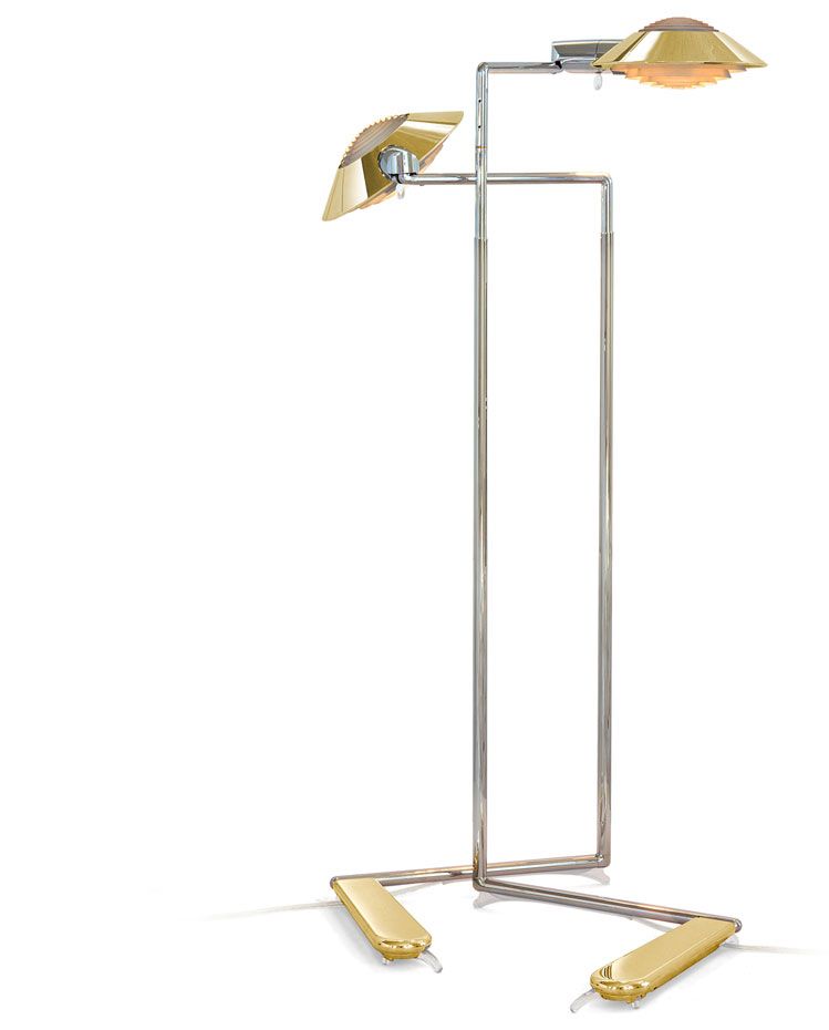 a floor lamp with two brass shades on a white background .