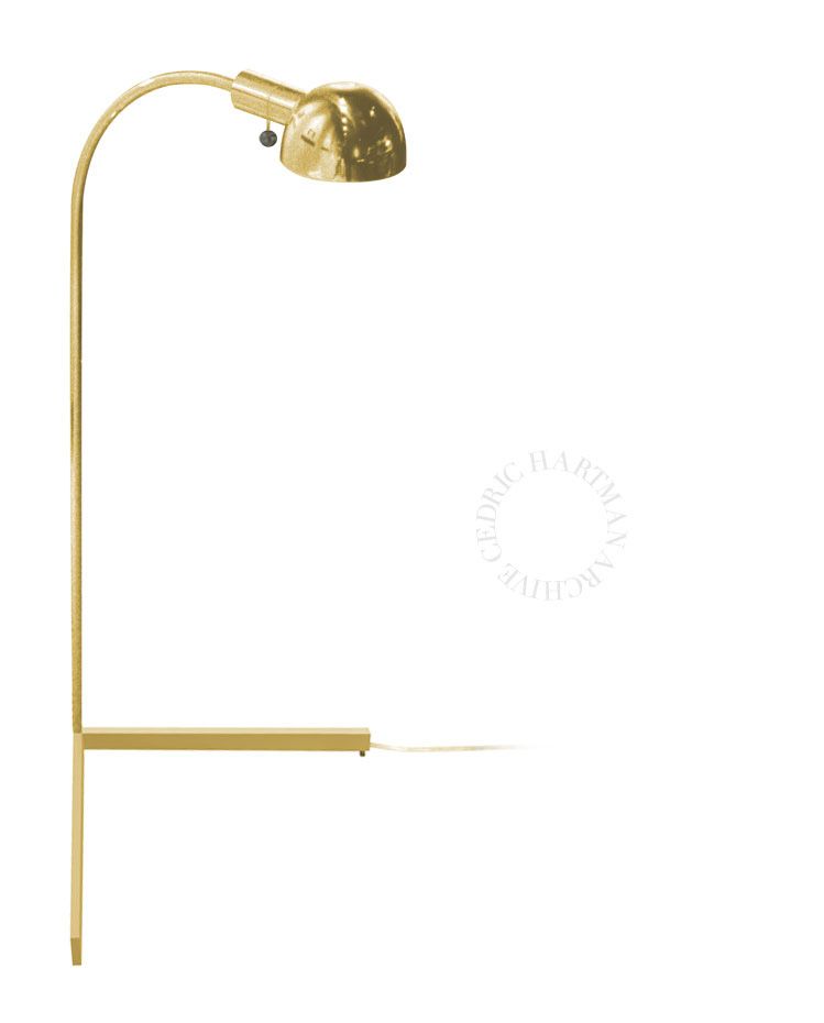 a brass lamp is sitting on a white surface .